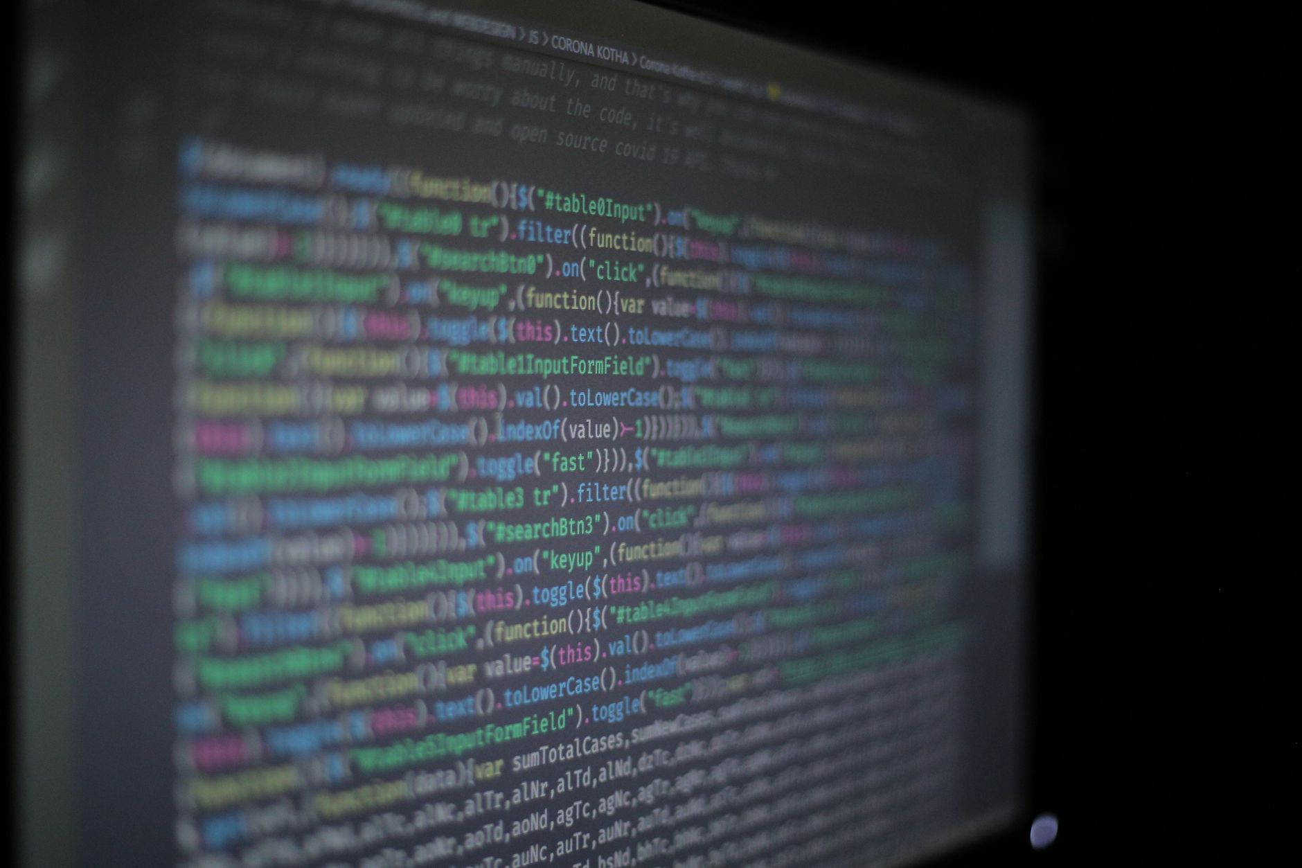 Primer plano de código de programación colorido en un monitor de ordenador desenfocado.