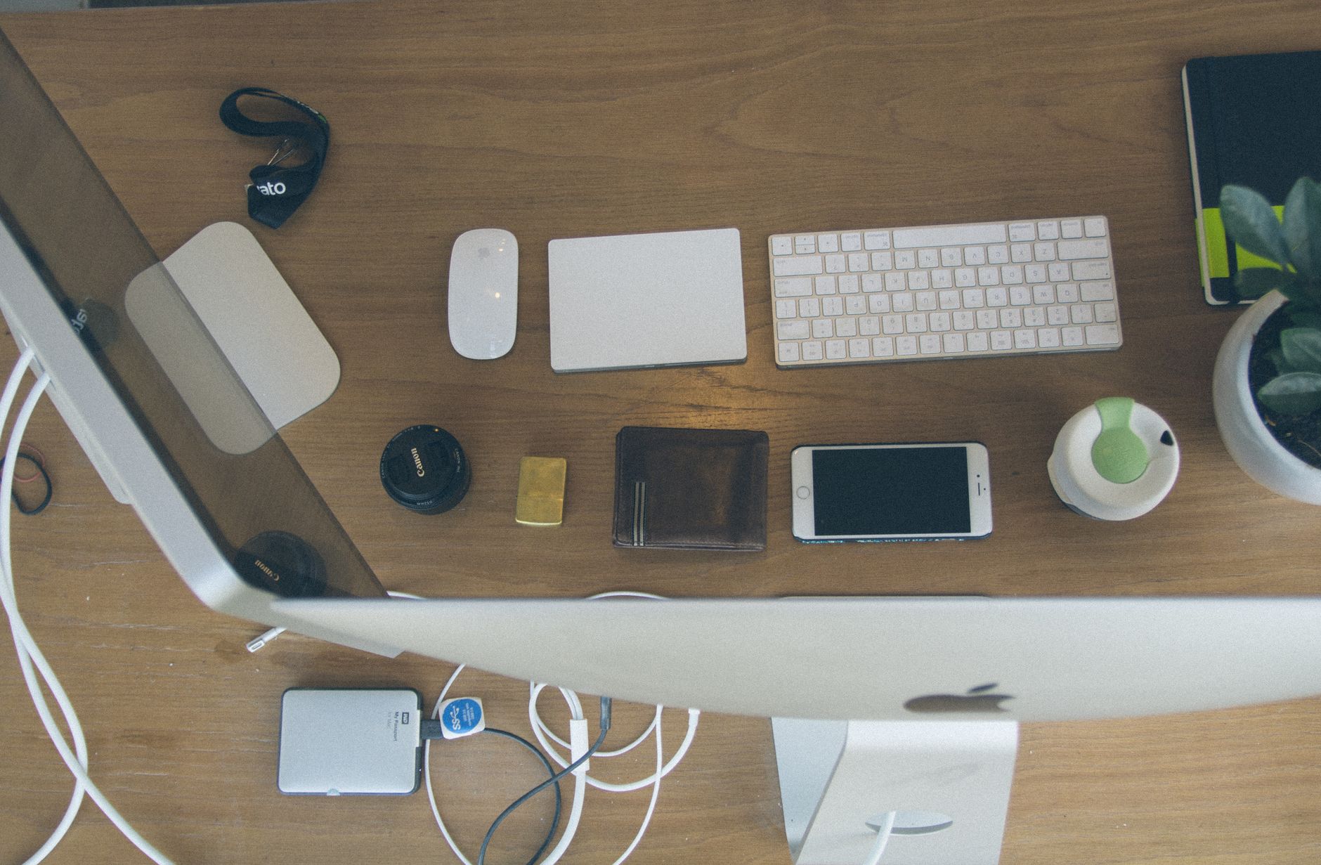 Vista cenital de un escritorio moderno y organizado con dispositivos y accesorios de Apple.